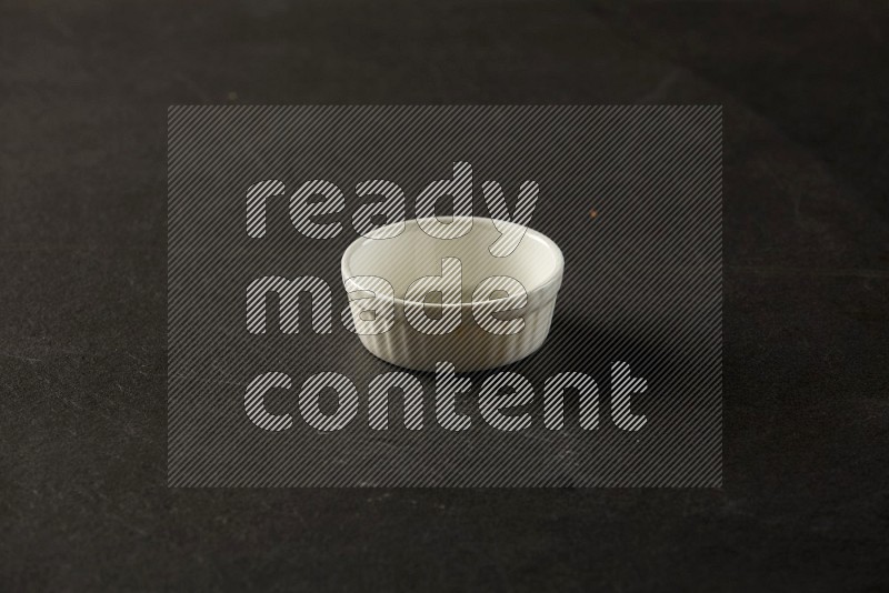 white ceramic round sauce bowl on grey textured countertop