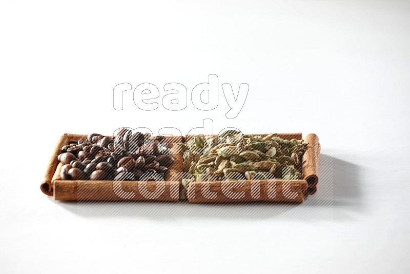 2 squares of cinnamon sticks full of cardamom and coffee beans on white flooring