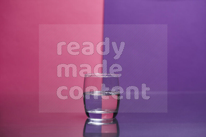 The image features a clear glassware filled with water set against pink and purple background