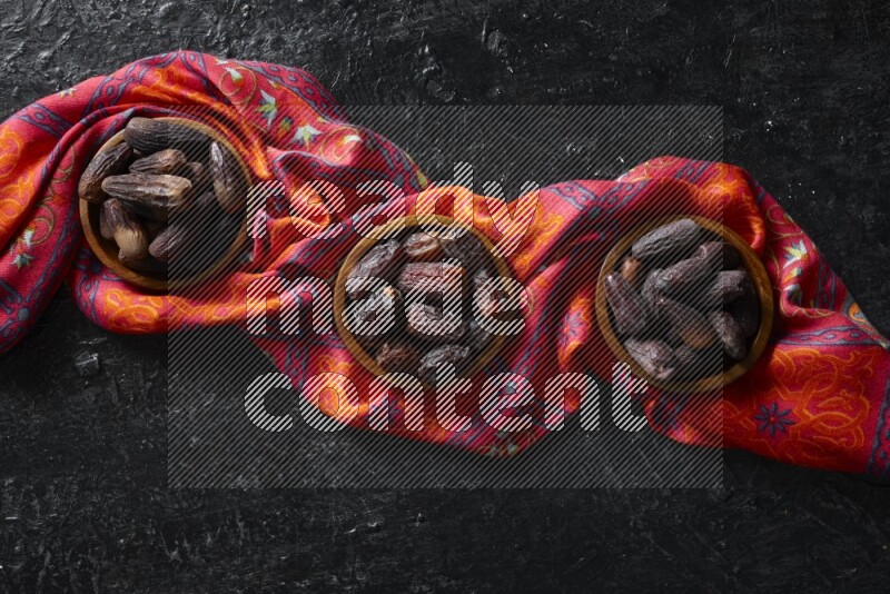 تمر في أطباق خشبية علي خلفية سوداء