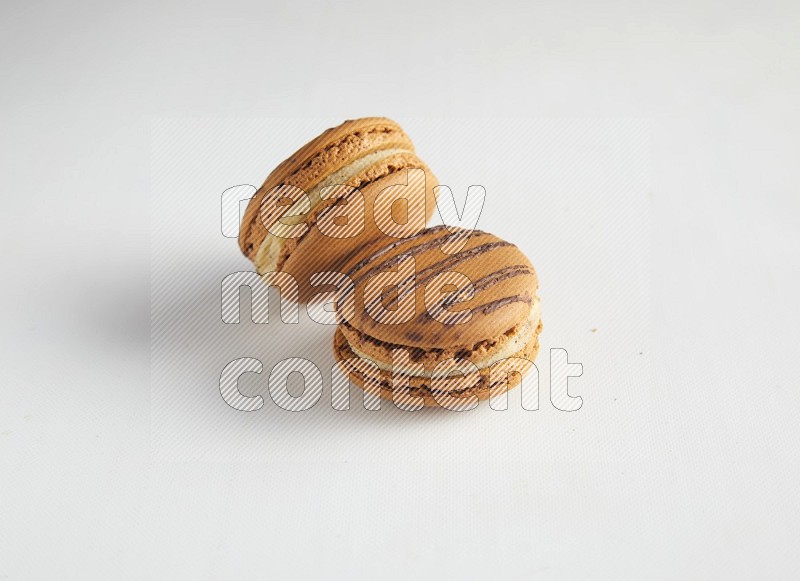 45º Shot of two light brown  Almond Cream macarons on white background