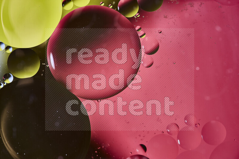 لقطات مقربة لفقاعات من الزيت على سطح الماء باللون الأصفر والوردي