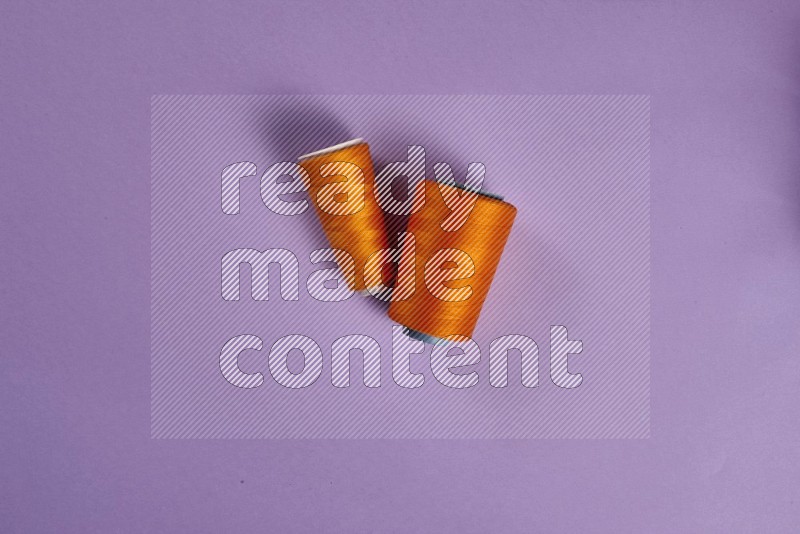 Orange sewing supplies on purple background
