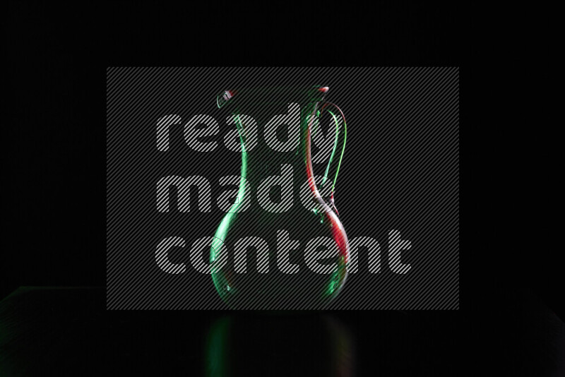 Glassware with rim light in red and green against black background