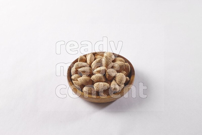 Almonds in a wooden bowl on white background