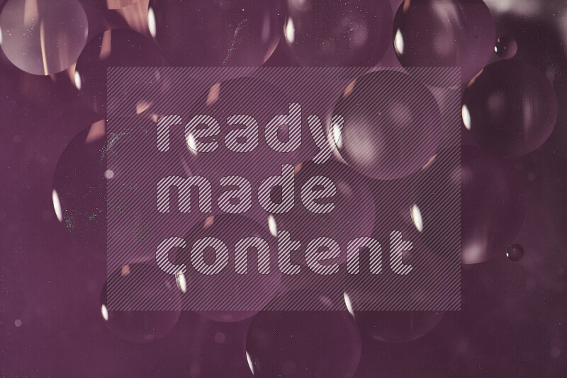 لقطات مقربة لفقاعات من الزيت على سطح الماء باللون الأرجواني