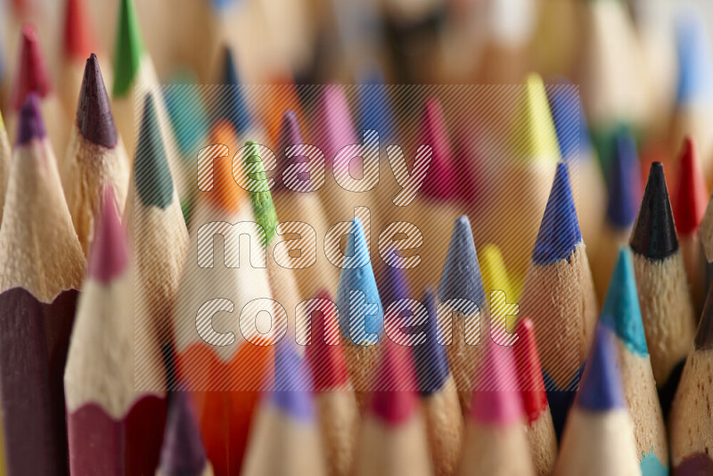The image captures a close-up of sharpened colored pencils on multicolored background