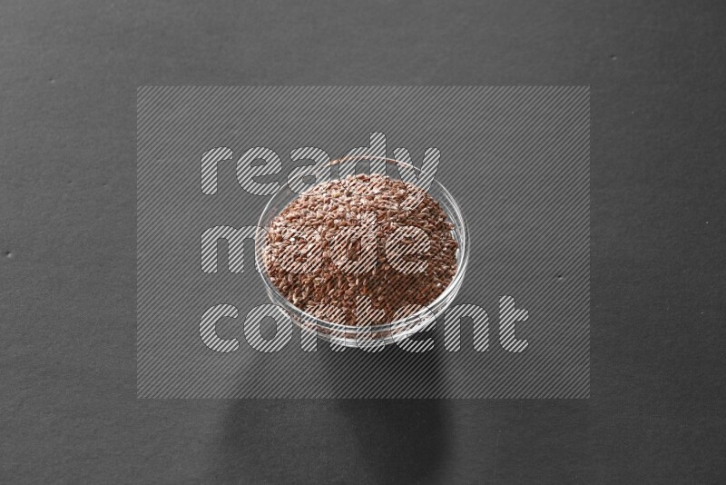 حبوب الكتان في وعاء زجاجي علي خلفية سوداء