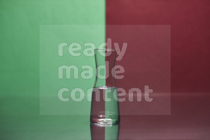 The image features a clear glassware filled with water, set against green and dark red background