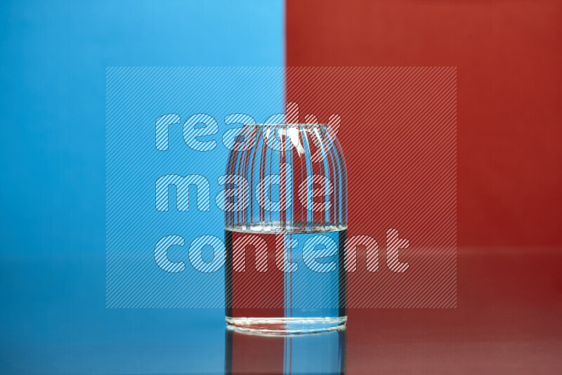 The image features a clear glassware filled with water, set against blue and red background