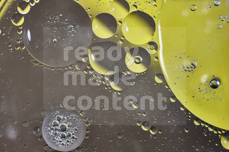 Close-ups of abstract oil bubbles on water surface in shades of yellow and brown