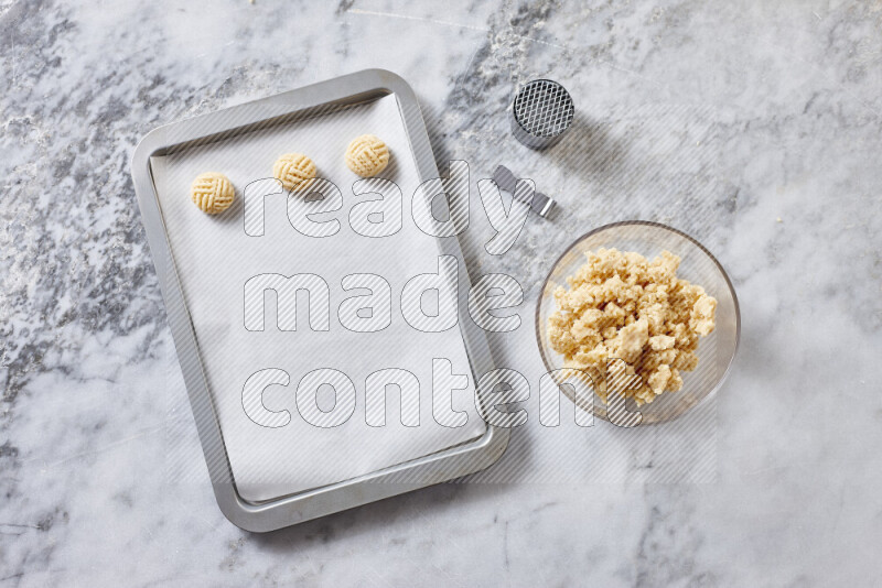 Kahk step by step with its ingredients ghee, sugar, flour, sesame, yeast, water and kahk flavor on grey marble background