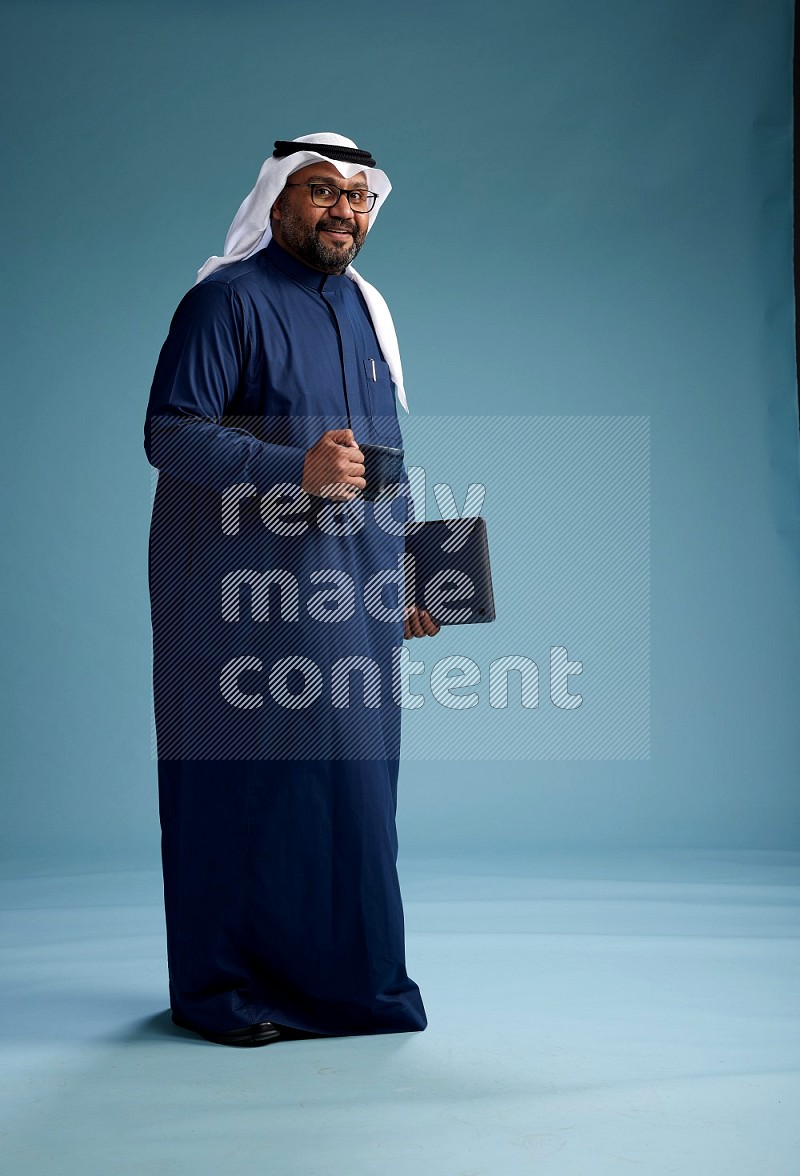 Saudi Man with shimag Standing drinking coffee on blue background