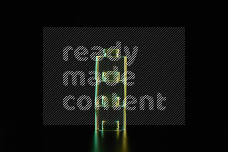 Glassware with rim light in green and yellow against black background