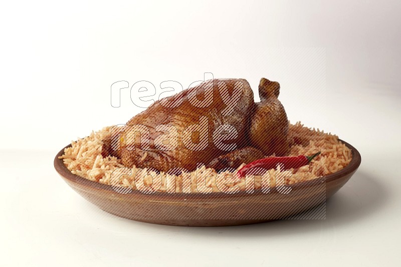 red basmati Rice with whole roasted chicken on a pottery plate direct on white background