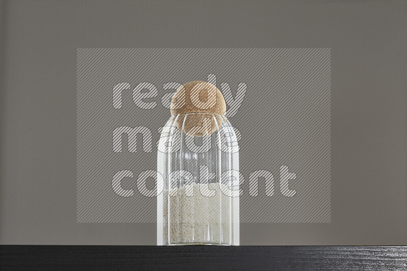 Desiccated coconut in a glass jar on black background