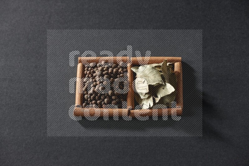 2 squares of cinnamon sticks full of allspice and bay laurel leaves on black flooring