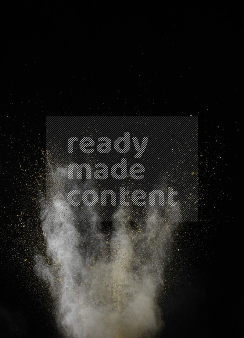 A side view of yellow powder explosion on black background