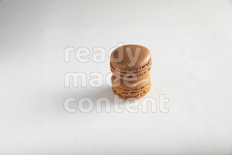 45º Shot of of two assorted Brown Irish Cream, and Brown Coffee macarons  on white background