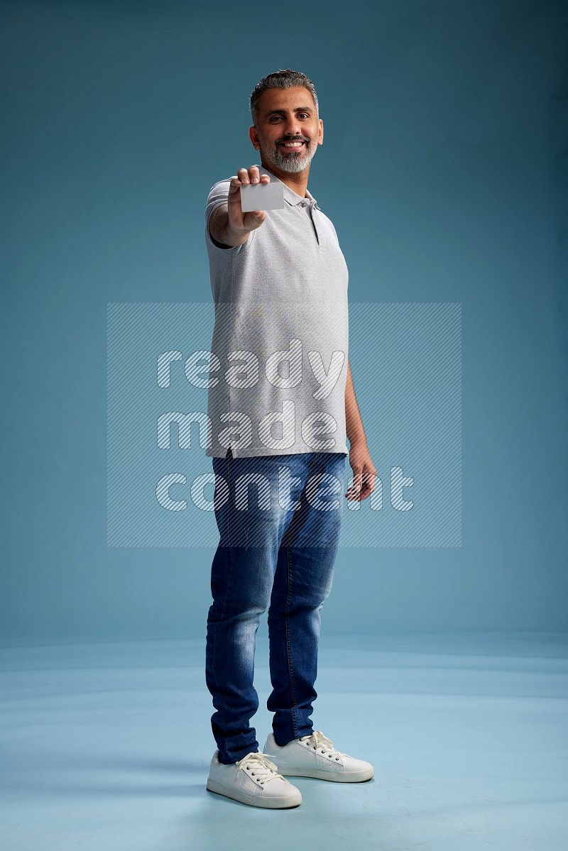 Man Standing holding ATM on blue background