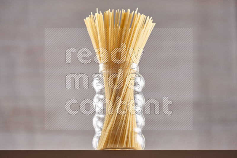 Raw pasta in glass jars on beige background
