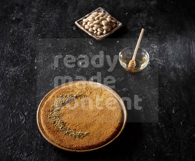 Konafa with nuts and honey in a dark setup