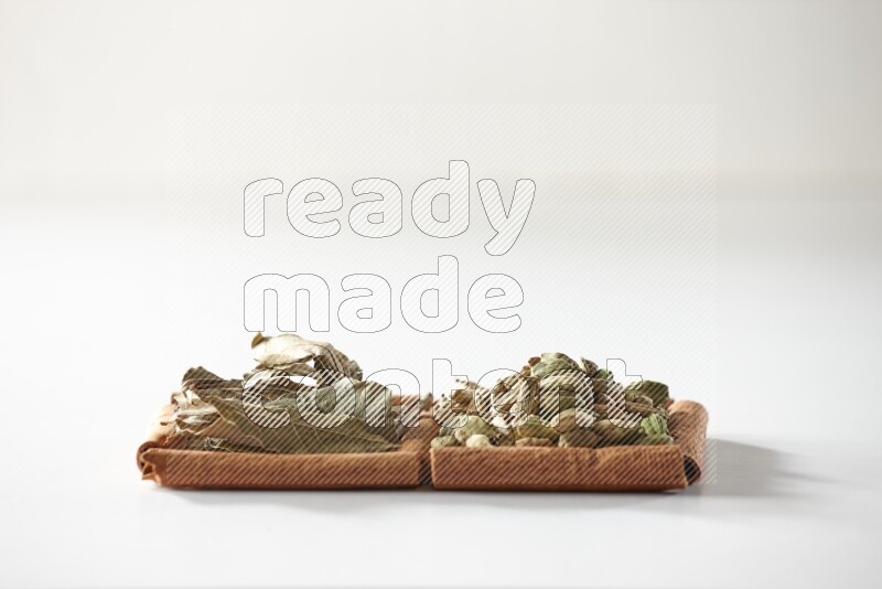 2 squares of cinnamon sticks full of cardamom and bay laurel leaves on white flooring