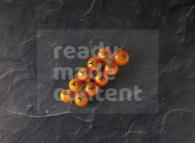 single cherry tomato vein topview on a black slate background