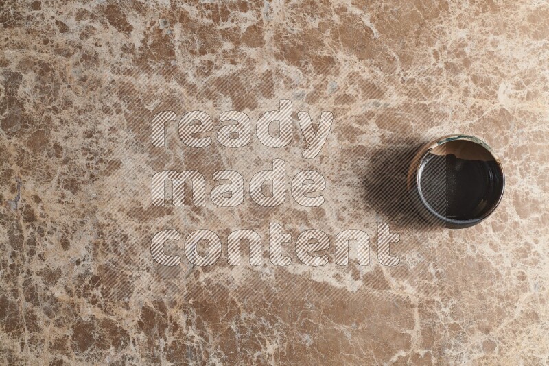 A multicolored pottery bowl on beige marble background