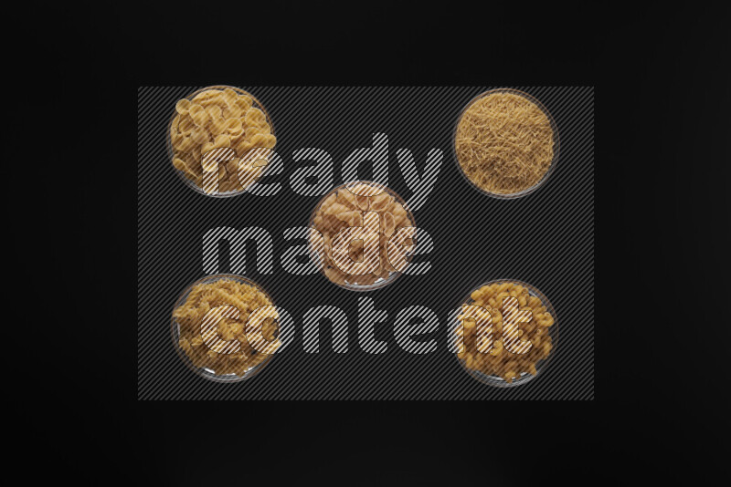 أنواع مختلفة من المعكرونة في أوعية زجاجية علي خلفية سوداء