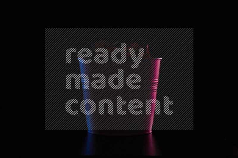 A plant pot with colored rim light against black background