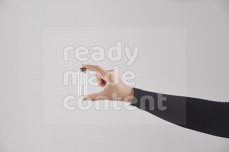 امرأة ترتدي عباءة سوداء تحمل أدوات زجاجية مختلفة في أوضاع متعددة