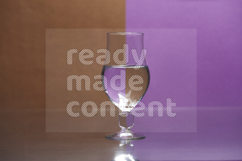 The image features a clear glassware filled with water, set against brown and purple background