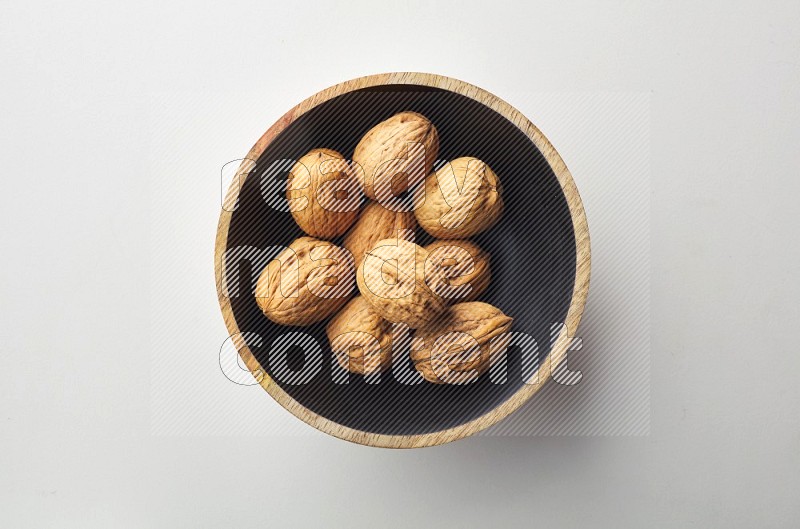 Top-view shot of walnut in a container on white background