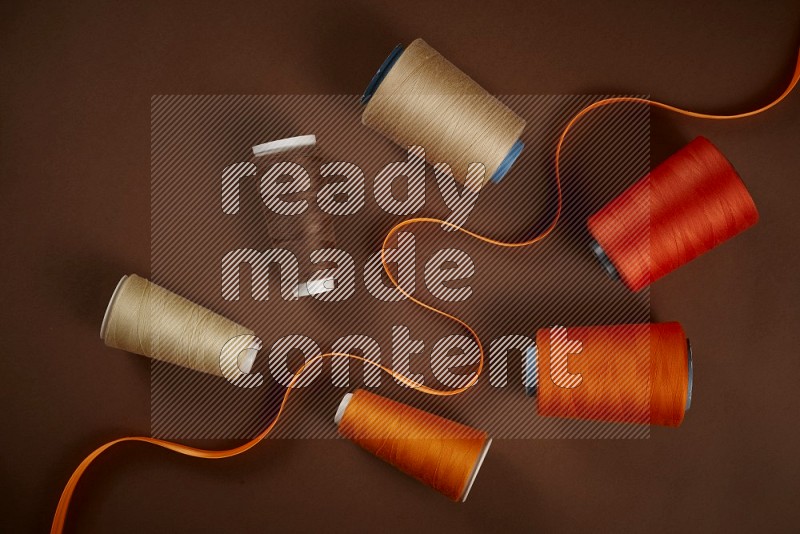 Orange sewing supplies on brown background