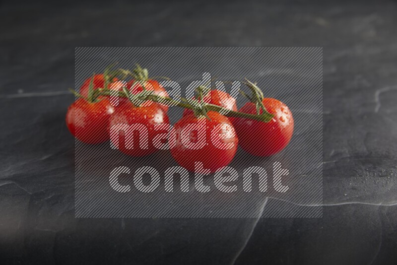 Red cherry tomato vein on a textured black slate background 45 degree
