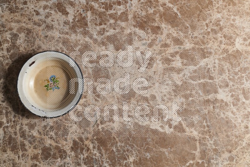 A vintage metal plate on beige marble background