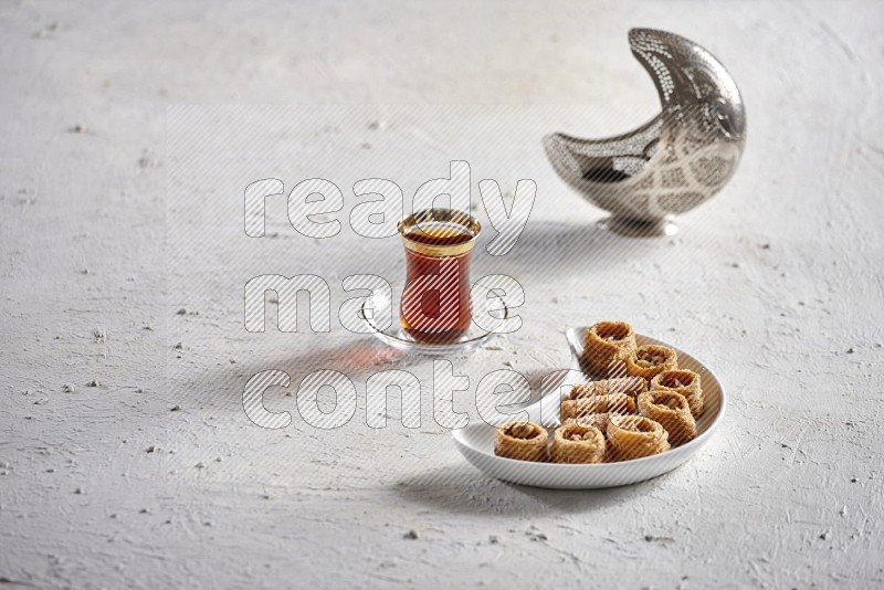 Konafa in a pottery plate with lantern and tea in a light setup