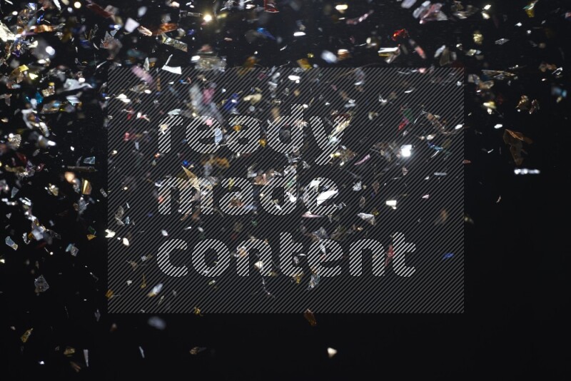 Falling multicolored confetti on black background