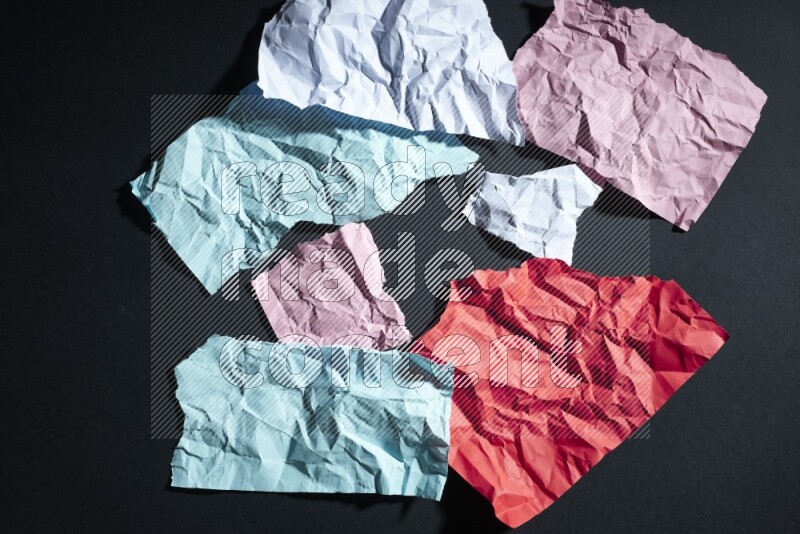 Crumpled multicolored paper on black background
