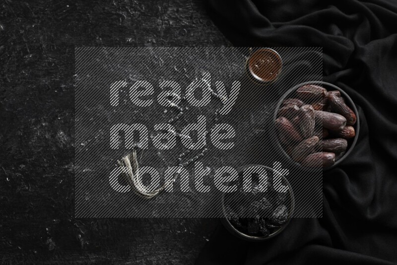 فواكه مجففة في أطباق فخارية مع القهوة علي خلفية سوداء خشبية