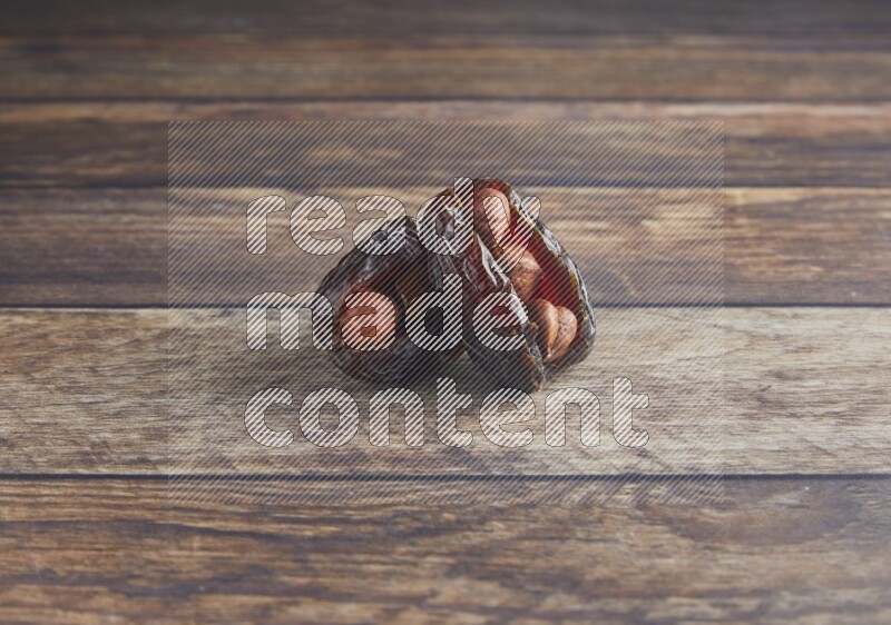 two hazelnut stuffed madjoul date on a wooden background