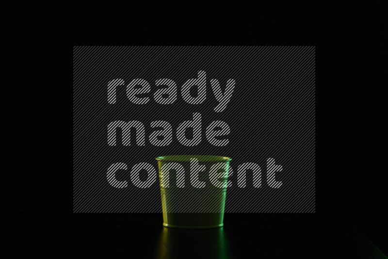 A plant pot with colored rim light against black background