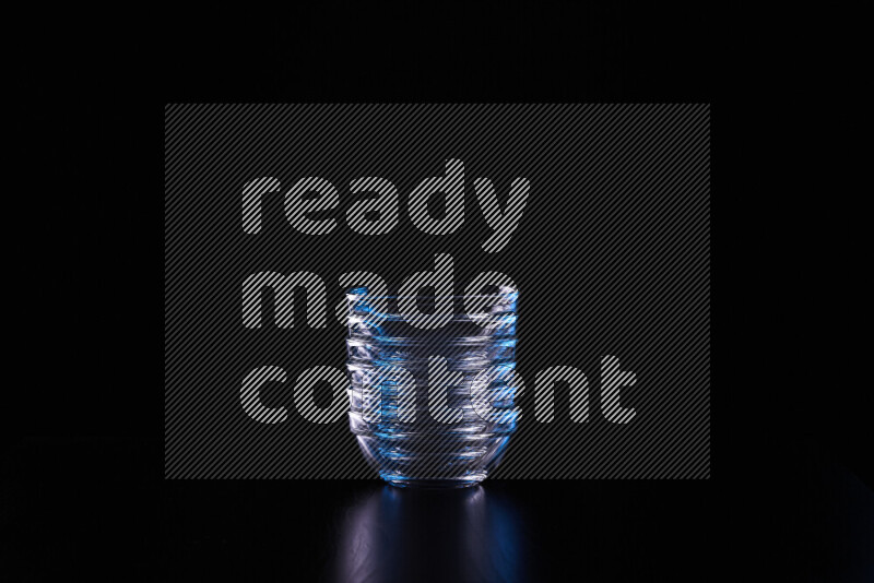 Glassware with rim light in blue and white against black background