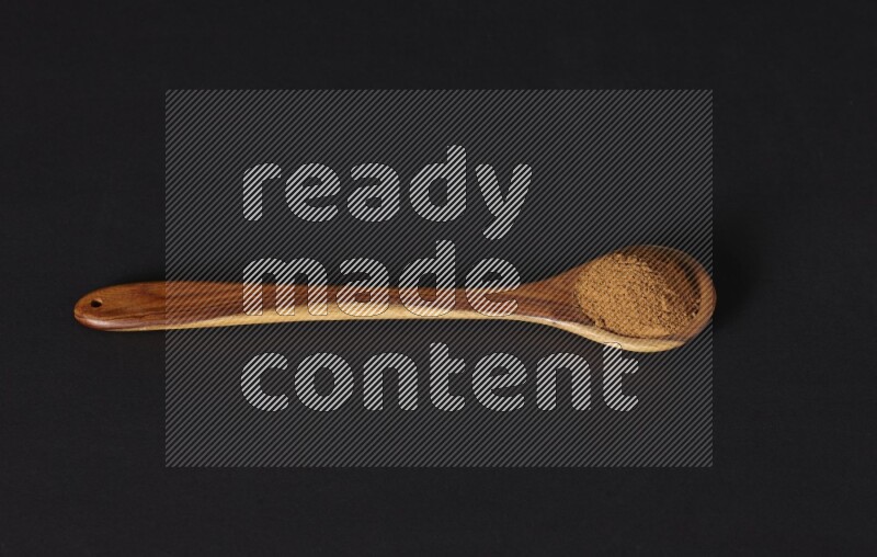 Cinnamon powder in a wooden ladle spoon on black background in different angles