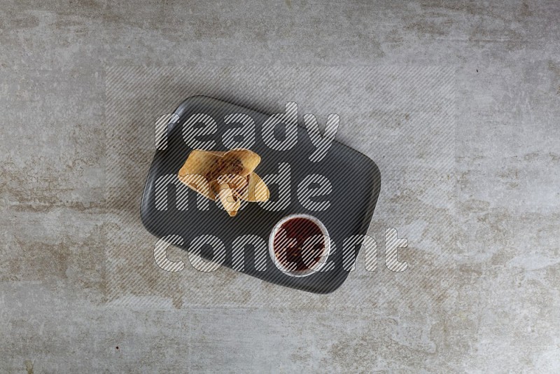 wonton cups with soy sauce ramkin on rectangle dark grey ceramic plate on grey textured counter top