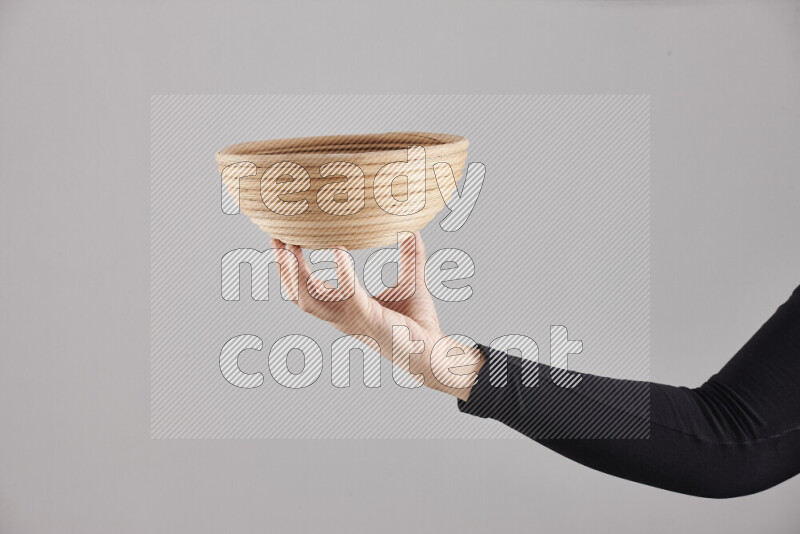 A woman in black abaya holding different wooden essentials in different positions