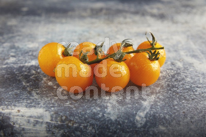 yellow cherry tomato vein on a textured rusty blue background 45 degree