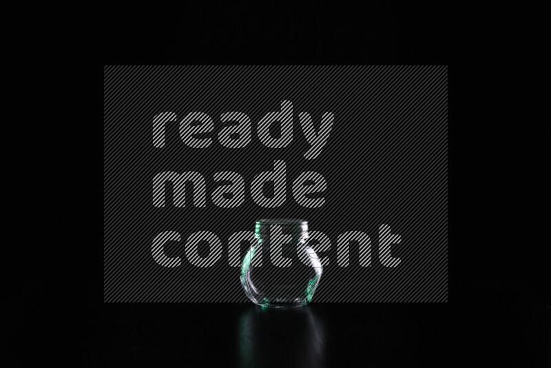 Glassware with rim light in green and white against black background