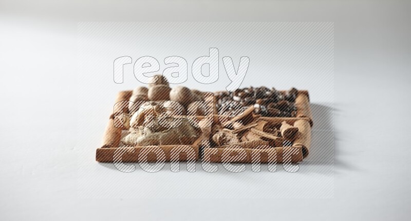 4 squares of cinnamon sticks full of coffee beans, nutmeg, cinnamon and dried ginger on white flooring